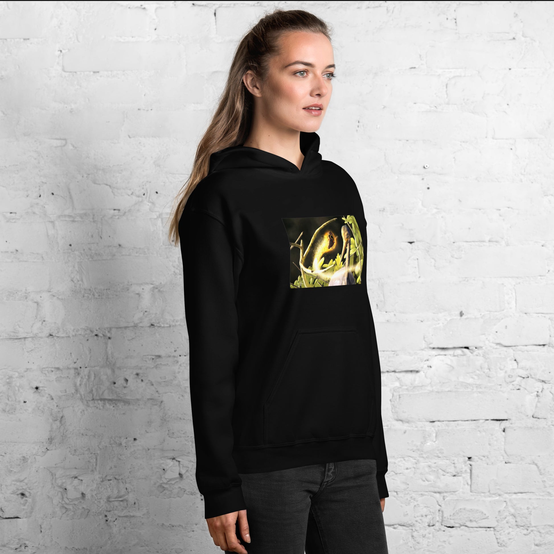 This printed hoodie of a digital painting is the first image in an ongoing series where animals meet special glowing insects face to face. In this particular encounter, a tricolor crane meets a luminescent butterfly. This digital wildlife animal painting print design is printed on a cozy hoodie.